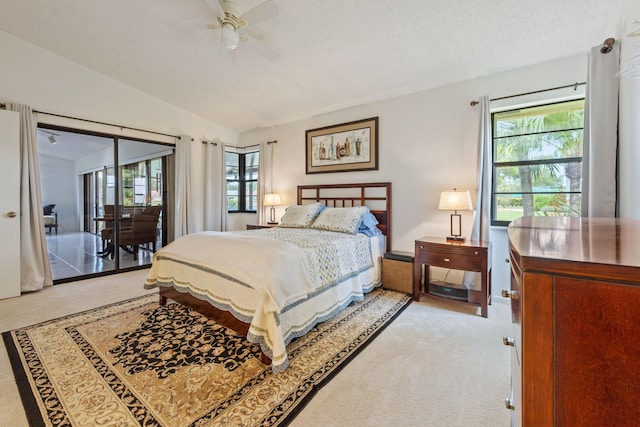 carpeted bedroom featuring ceiling fan, access to exterior, lofted ceiling, and a textured ceiling