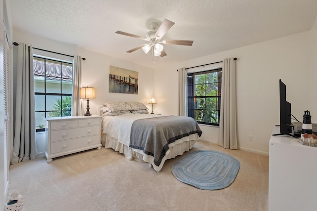 carpeted bedroom with a textured ceiling and ceiling fan