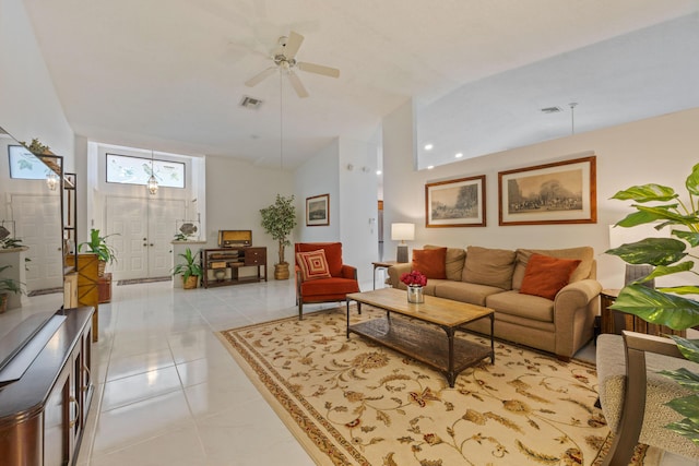 living room with ceiling fan, light tile patterned floors, and lofted ceiling