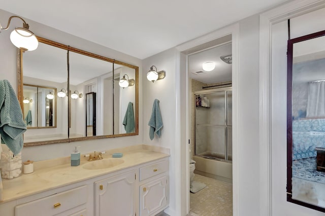 full bathroom with tile patterned flooring, vanity, toilet, and bath / shower combo with glass door