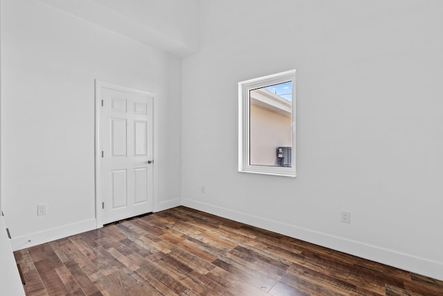 unfurnished room with dark wood-type flooring