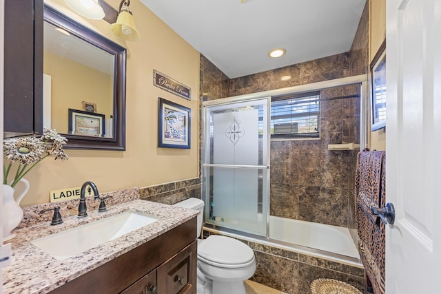 full bathroom with tile walls, tiled shower / bath combo, vanity, and toilet