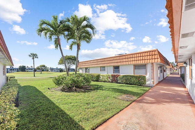 exterior space featuring a tile roof and a front lawn