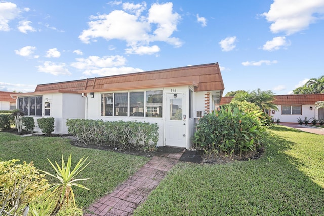 view of front of house with a front yard and stucco siding