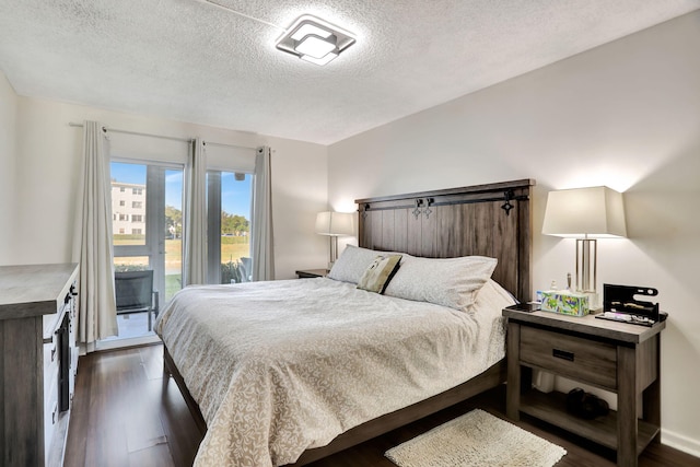 bedroom with dark wood-type flooring, a textured ceiling, and access to outside