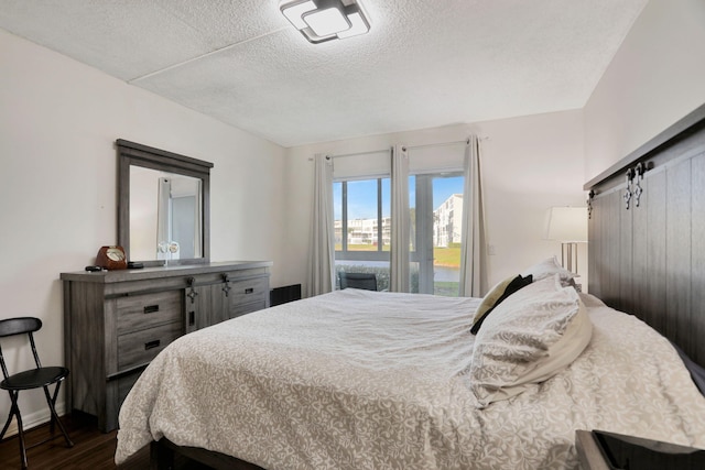 bedroom featuring dark wood-type flooring and a textured ceiling