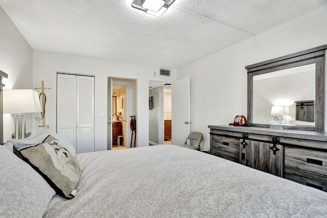 bedroom featuring connected bathroom, a closet, and a textured ceiling