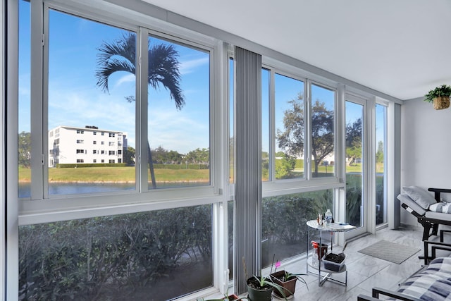 sunroom / solarium featuring a water view