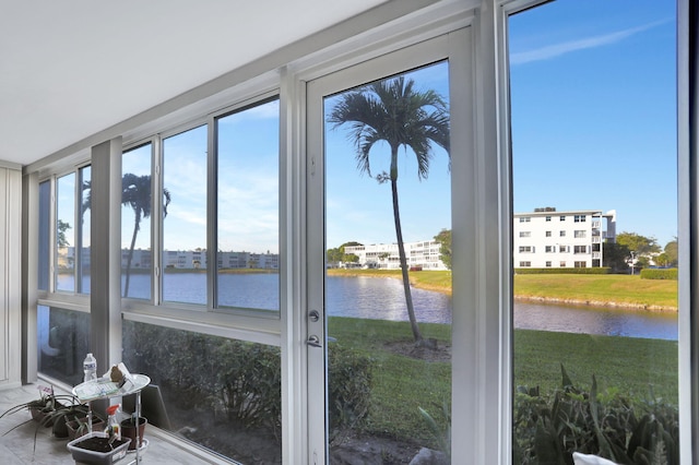 sunroom featuring a water view