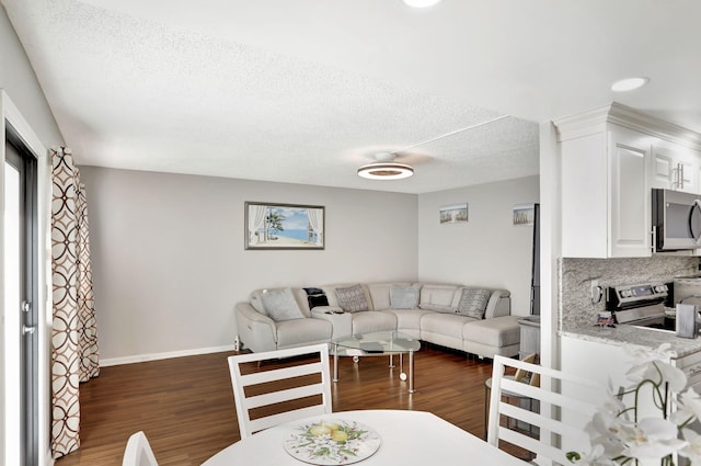 living room with a textured ceiling and dark wood-type flooring