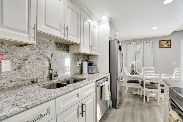 kitchen featuring tasteful backsplash, appliances with stainless steel finishes, sink, and white cabinetry