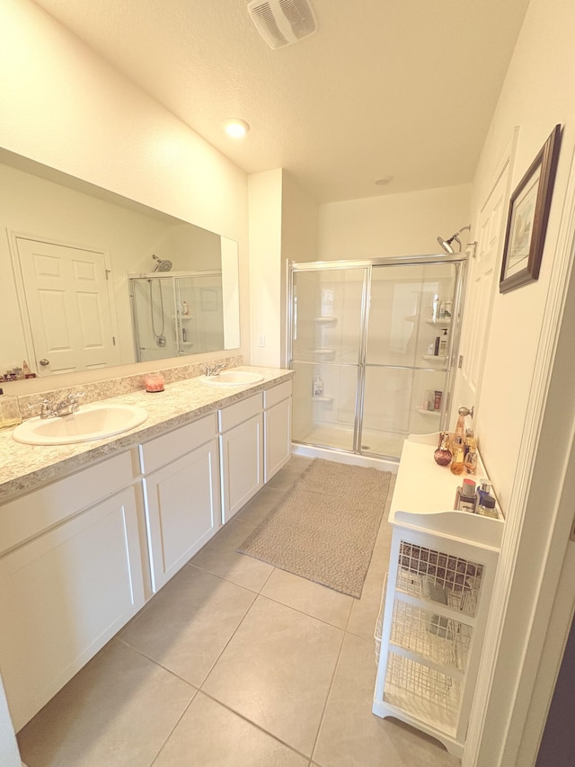 bathroom featuring tile patterned flooring, vanity, and a shower with shower door