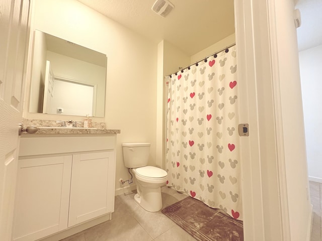 bathroom featuring vanity, tile patterned floors, toilet, and walk in shower