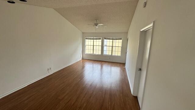 unfurnished room featuring a textured ceiling, dark wood-type flooring, ceiling fan, and lofted ceiling