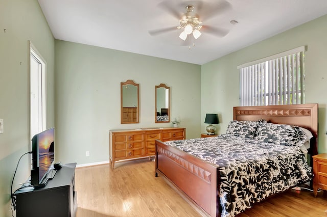 bedroom with ceiling fan, light hardwood / wood-style floors, and multiple windows