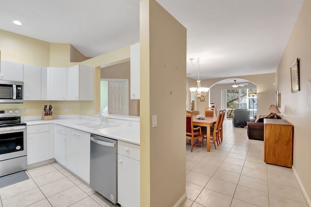 kitchen with light tile patterned floors, stainless steel appliances, white cabinets, and sink