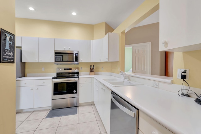 kitchen featuring light tile patterned floors, sink, white cabinets, and stainless steel appliances