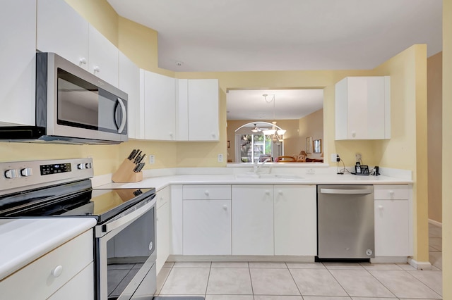 kitchen with appliances with stainless steel finishes, sink, white cabinetry, and light tile patterned flooring