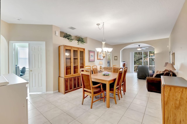 tiled dining room with ceiling fan with notable chandelier