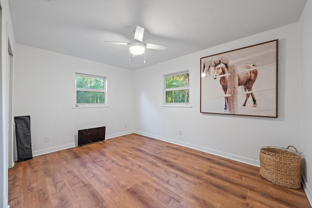 empty room with ceiling fan and wood-type flooring