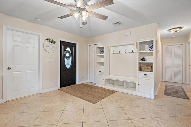 tiled foyer featuring ceiling fan and a textured ceiling