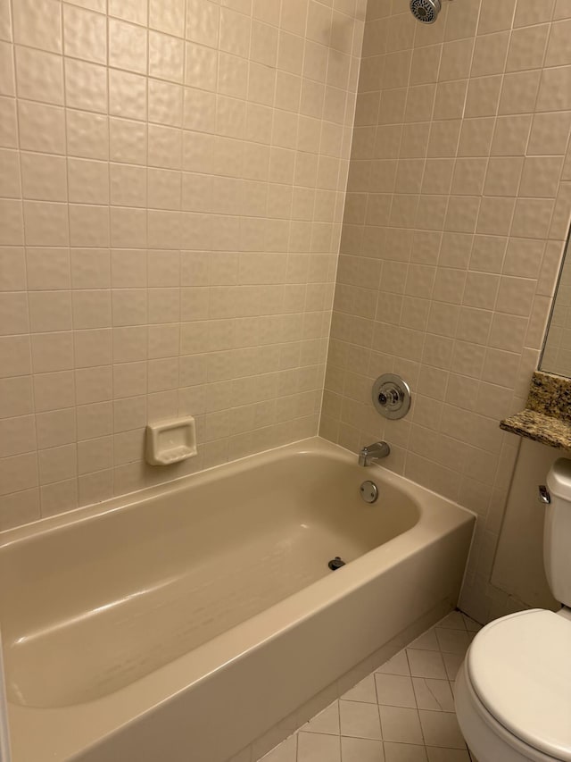 full bathroom featuring vanity, tiled shower / bath combo, tile patterned floors, and toilet