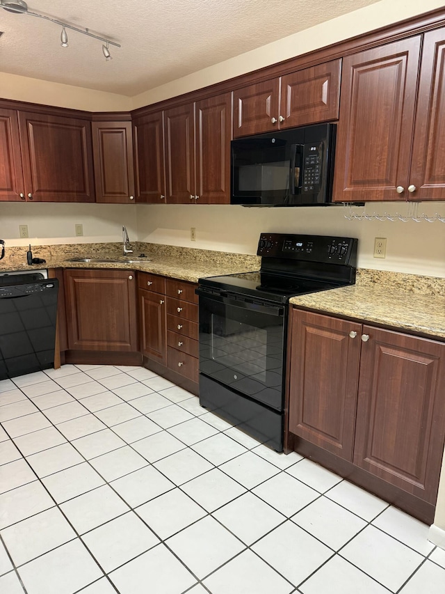 kitchen featuring light stone countertops, sink, a textured ceiling, and black appliances