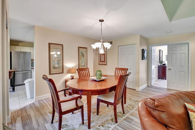 dining room featuring a notable chandelier and light wood-type flooring