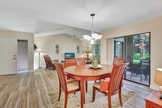 dining room with light wood-type flooring, vaulted ceiling, and plenty of natural light