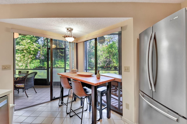 tiled dining space with a textured ceiling