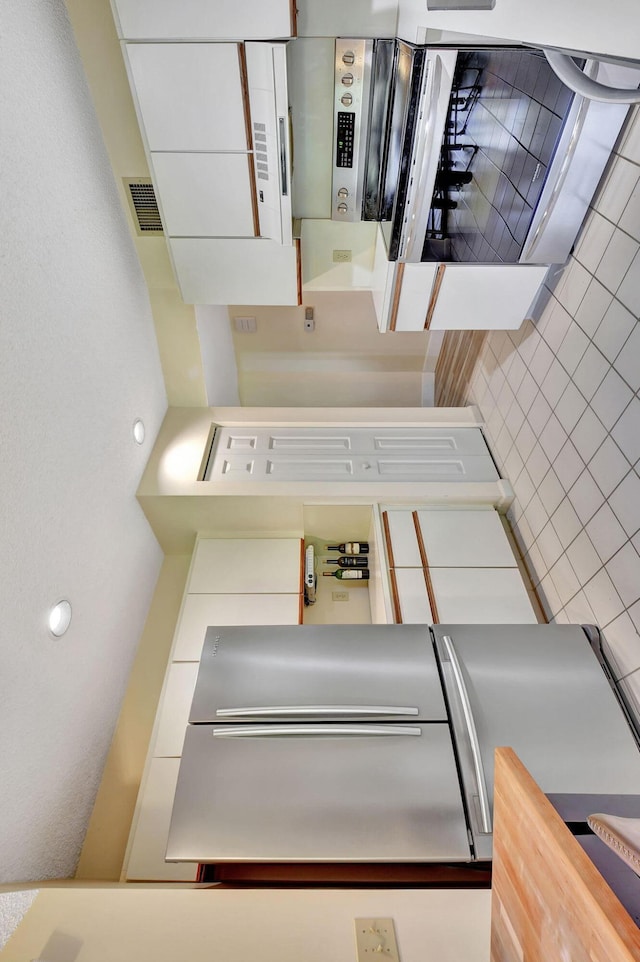 kitchen featuring white cabinetry and wood counters