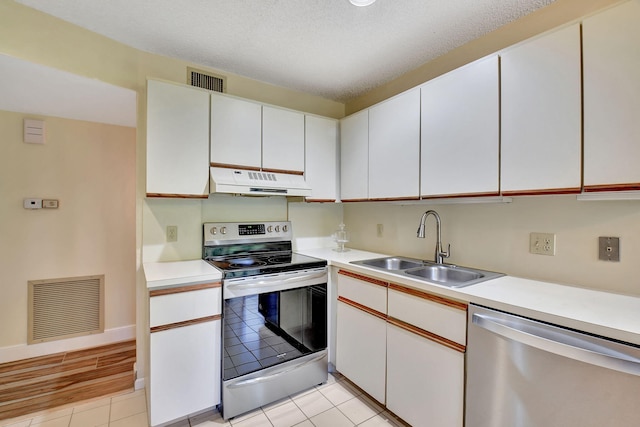 kitchen with sink, white cabinets, light hardwood / wood-style floors, and appliances with stainless steel finishes