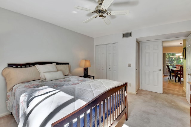 carpeted bedroom featuring ceiling fan and a closet