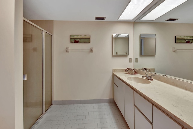 bathroom featuring tile patterned floors, vanity, and walk in shower