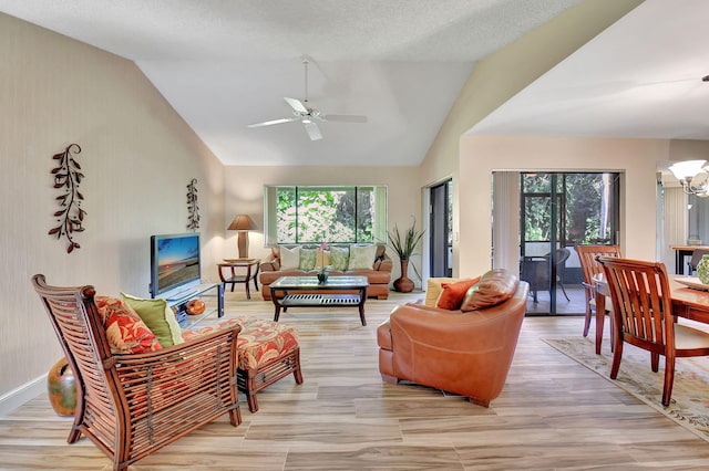 living room with a textured ceiling, ceiling fan with notable chandelier, light hardwood / wood-style floors, and lofted ceiling