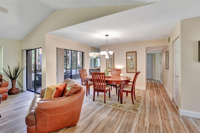 dining space with a chandelier, light hardwood / wood-style flooring, and vaulted ceiling