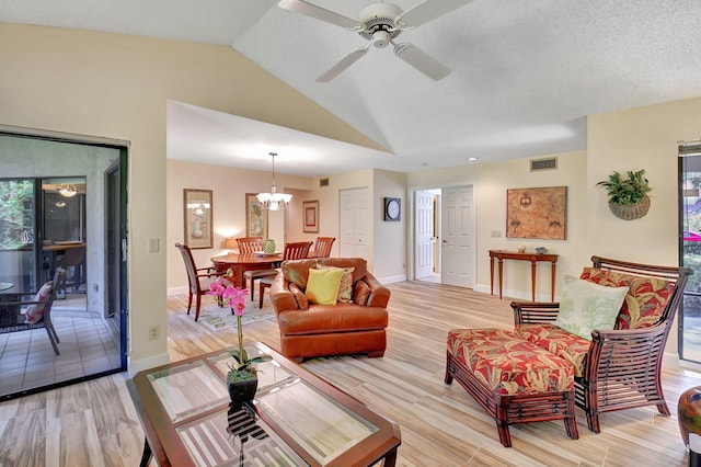 living room with ceiling fan with notable chandelier, light hardwood / wood-style floors, plenty of natural light, and lofted ceiling