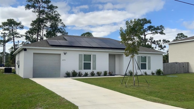 ranch-style house with solar panels, central AC unit, a garage, and a front lawn