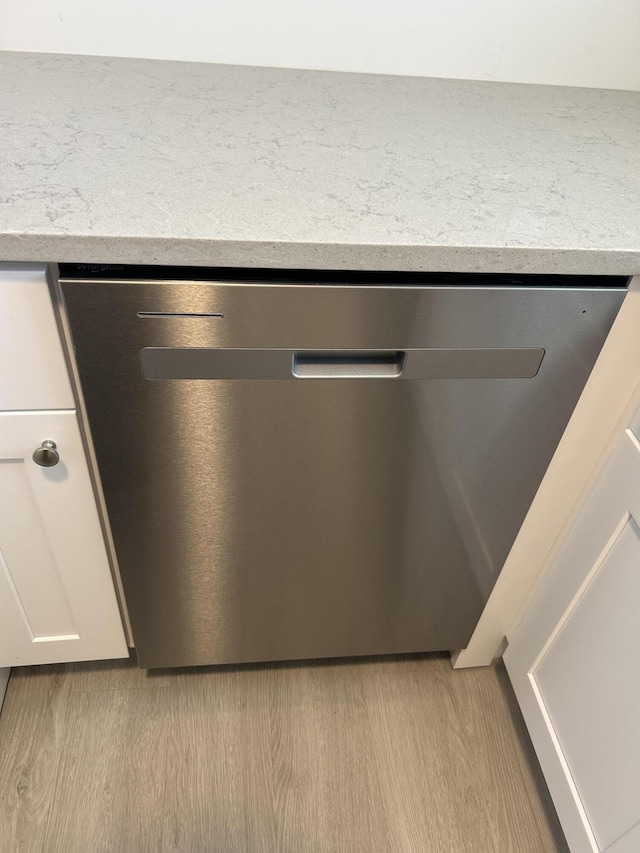 room details with dishwasher, white cabinets, and light hardwood / wood-style floors