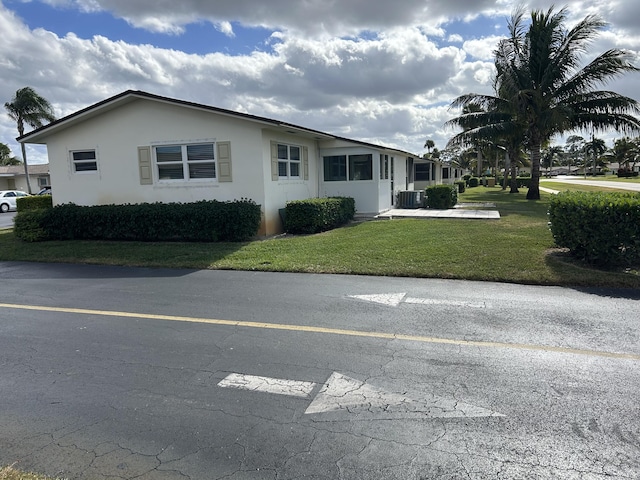 view of front of property featuring a front yard and central AC