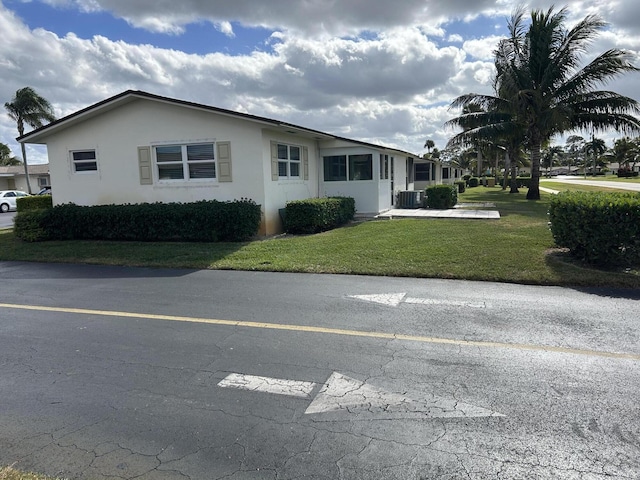 single story home featuring a front lawn and central AC unit