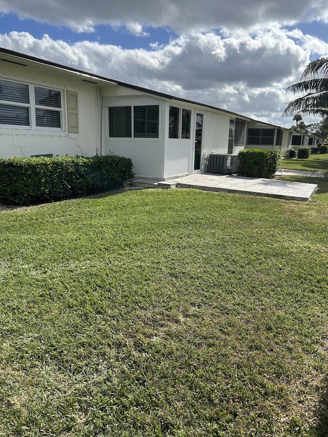 ranch-style home featuring central AC unit and a front yard