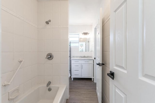 bathroom with vanity, tiled shower / bath combo, and hardwood / wood-style flooring