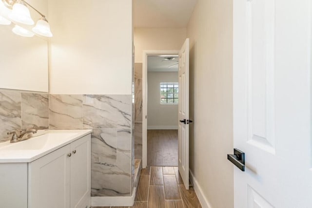 bathroom with vanity, hardwood / wood-style flooring, and tile walls