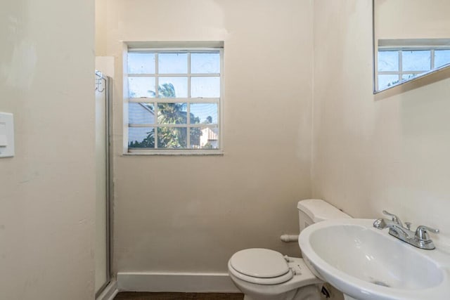 bathroom with toilet, walk in shower, and sink