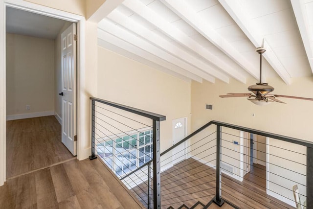 staircase with beam ceiling, ceiling fan, and wood-type flooring