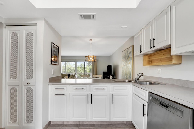 kitchen featuring white cabinets, dishwasher, light tile patterned floors, and decorative light fixtures