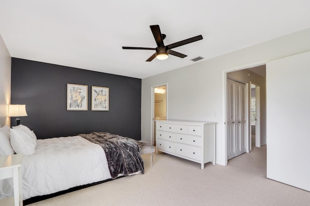 carpeted bedroom with ceiling fan and ensuite bath