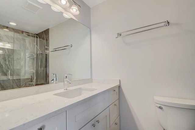 bathroom with a shower with door, vanity, and toilet