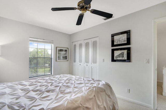 bedroom featuring ceiling fan, light colored carpet, and a closet